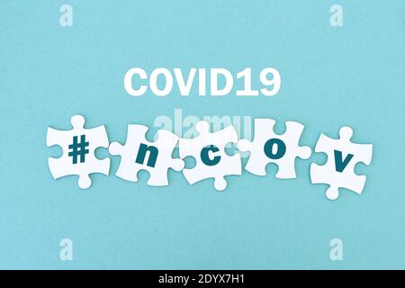 Covid 19 Jigsaw puzzle pieces on a blue background Stock Photo
