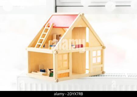 Beautiful wooden dollhouse on light room background Stock Photo