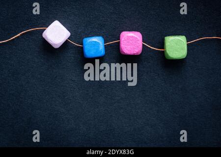Bright wooden cube beads on thread macro with copy space Stock Photo
