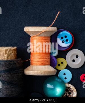 Colorful sewing buttons and orange thread spool macro Stock Photo