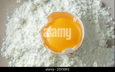 Broken raw chicken egg with flour, top view Stock Photo