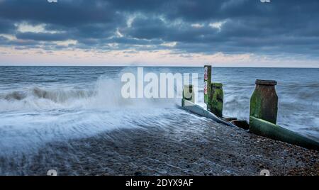 Waves break against a groyne. Stock Photo