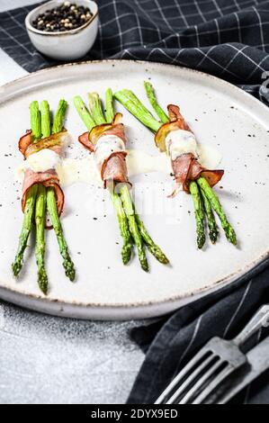 Grilled organic asparagus wrapped in pork bacon. Gray background. Top view Stock Photo