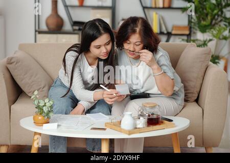 Mother and daughter checking bills Stock Photo