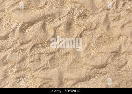 Sand underwater background texture. Clear ripple sea wave and white sand. Top view Stock Photo