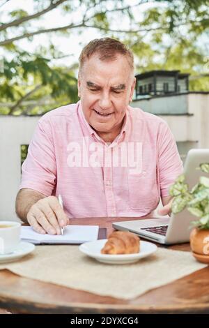 Senior man checking data in planner Stock Photo