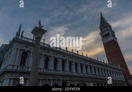 Venice, Italy - June 22, 2014:  The glow of a sunset surrounds St Mark's Campanile, the bell tower of St Mark's Basilica in Venice. Stock Photo