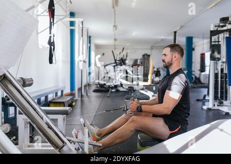 Young man Doing Heavy Weight Exercise For Back On Machine, Focus on him. Concept of health. Stock Photo