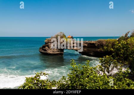 Batu Bolong Temple built on the natural rock formation bridge close to Tanah Lot temple Stock Photo