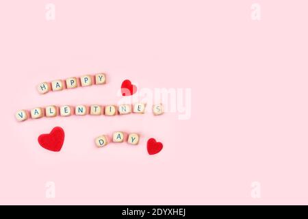 Paper red hearts with saint valentine´ s greeting on a pink background Stock Photo