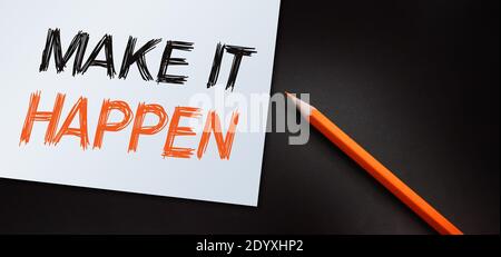 Make It Happen written with orange pencil. Used in business, life and sports coaching well known phrase for getting things done. Stock Photo