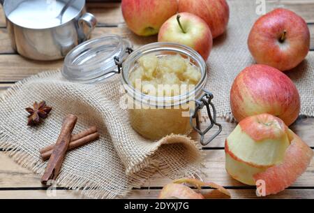 homemade compote  in a glass  jar with red apples  and spices on a wooden  table Stock Photo