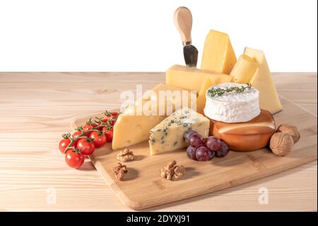 still life cheese isolated on white background. composition different types of cheese with walnuts, tomato and grapes. Assortment of different cheese. Stock Photo