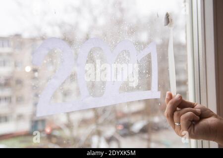 Numbers 2021 of new year paper cut on window. Create window decor from toothpaste Stock Photo