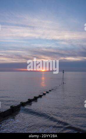 Half submerged groyne at sunset on Hunstanton Beach, Norfolk, England Stock Photo