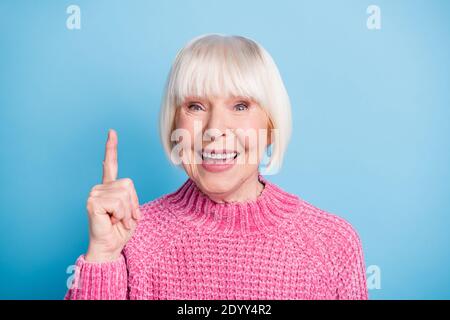 Photo portrait of happy old lady having idea raising finger up isolated on pastel blue colored background Stock Photo