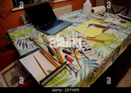 Acrylic paints and brushes laid out on a domestic table during a painting session Stock Photo