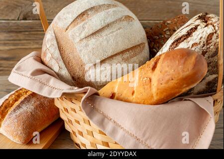 Composition of various baked products in basket on rustic background. Homemade fresh pastry