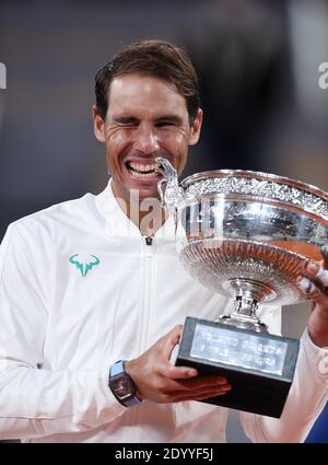 (201228) -- BEIJING, Dec. 28, 2020 (Xinhua) -- Rafael Nadal of Spain celebrates with his trophy during the awarding ceremony after winning the men's singles final match against Novak Djokovic of Serbia at the French Open tennis tournament 2020 at Roland Garros in Paris, France, Oct. 11, 2020. On October 11, Rafael Nadal lifted his 13th title at Roland Garros, equaling Roger Federer's men's all-time record of 20 Grand Slam singles titles. On November 4, the Spaniard became the fourth player in history to reach 1,000 Tour-level wins at the ATP Paris Masters, joining Jimmy Connors, Federer, and Stock Photo