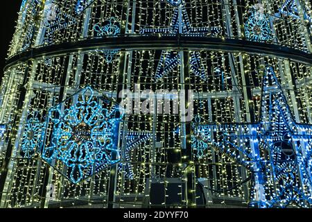 Many tiny light bulbs making a shiny Christmas winter decoration on a dark black background Stock Photo