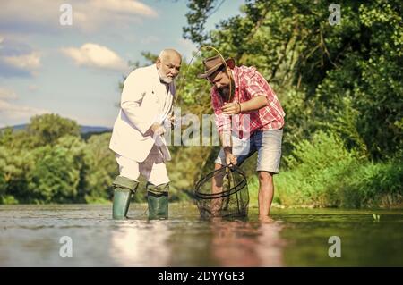 best friends. father and son fishing. Poaching. Camping on the shore of  lake. concept of a rural getaway. hobby. wild nature. happy fisherman with  fishing rod and net. Big game fishing. friendship