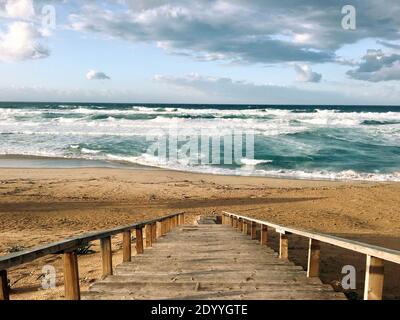 Stairs going down the a beautiful beach near by the wavy Mediterranean sea on sunset evening time in Skikda Algeria