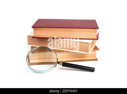Stack of books, textbooks with magnifying glass isolated on white background. Stock Photo