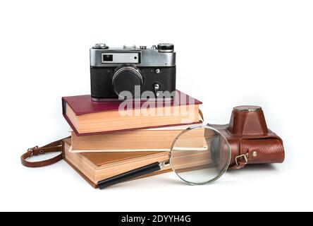 Vintage camera, books and magnifier isolated on white background. Stock Photo