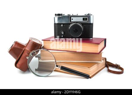Books, camera and magnifying glass isolated on white background. Stock Photo