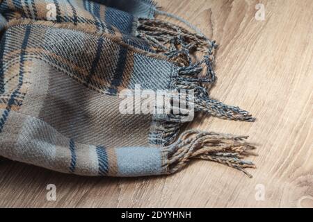 woolen blue and grey colored scarf on a wooden  floor Stock Photo