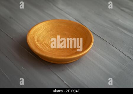 golden handmade painted wooden plate on grey background Stock Photo