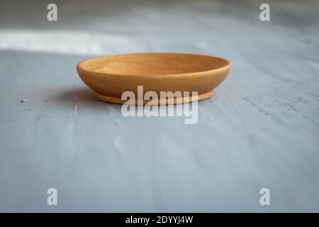 golden handmade painted wooden plate on grey background Stock Photo
