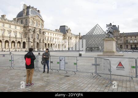 Paris, France. 28th Dec, 2020. A tourist pose for a photo at the deserted Napoleon courtyard near the closed Louvre museum amid the coronavirus pandemic on December 28, 2020 in Paris, France. According the latest report of the French National Authority for Health (HAS) 175 people died in hospital, and 8,822 new cases of Covid-19 infection, strict measures are still in place as curfew from 8:00 p.m. to 6:00 a.m. was put in place in all territory French. (Photo by Paulo Amorim/Sipa USA) Credit: Sipa USA/Alamy Live News Stock Photo