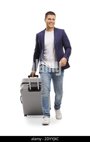 Full length portrait of a man smiling and walking towards camera with a suitcase isolated on white background Stock Photo