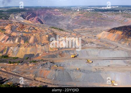 Heavy dump truck carrying the iron ore on the opencast mining aerial view. Stock Photo