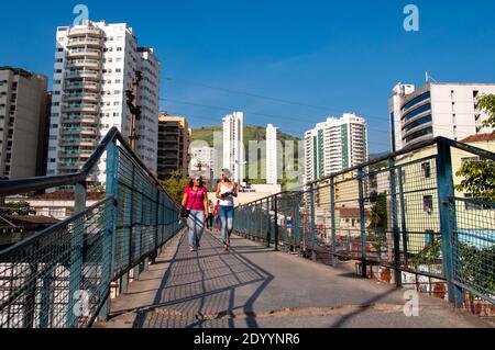 Nova Iguacu, RJ, Brazil - April 12, 2015: Footbridge in city center. People crossing. Tall apartment buildings on the other side. Stock Photo