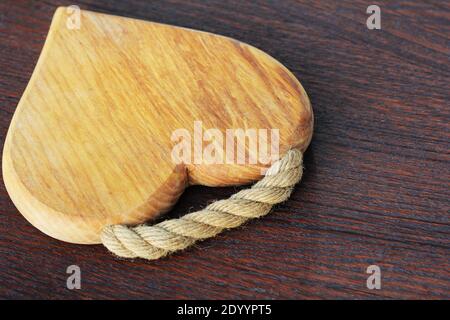 Heart shaped cutting board on rustic wooden background . Stock Photo
