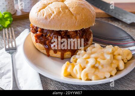 Hot, fresh pulled pork barbecue sandwich with macaroni and cheese on a plate Stock Photo