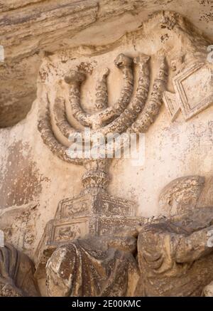 Detail of the Golden Menorah in the Arch of Titus, located on the Via Sacra, just to the south-east of the Roman Forum in Rome, Italy, which was built to commemorate Titus's victory in Judea, depicts a Roman victory procession with soldiers carrying spoils from the Temple, including the Menorah, which were used to fund the construction of the Colosseum, on Wednesday, October 23, 2013. It was constructed c. 82 AD by the Roman Emperor Domitian shortly after the death of his older brother Titus to commemorate Titus' victories, including the Siege of Jerusalem in 70 AD. The Arch is said to have pr Stock Photo