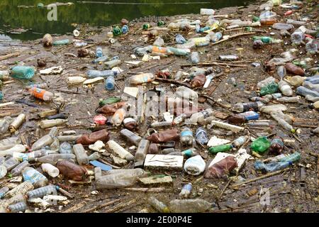 Environment pollution. Lake full of plastic bottles and garbage in the mountains. Stock Photo