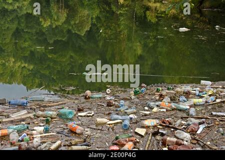 Environment pollution. Lake with plastic bottles and garbage in the mountains. Stock Photo