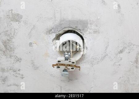 A man dismantles and mends an electrical outlet for repairs. Power socket. Stock Photo
