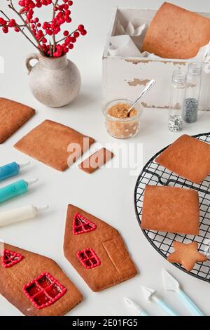 Making of gingerbread house, baked details arranged on white background. Xmas festive background, isometric projection. Creative handmade project for Stock Photo