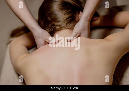 Body care. Young girl having massage, relaxing in spa salon, closeup