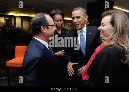 French President Francois Hollande with his companion Valerie Trierweiler meets US President Barack Obama next to Michelle Obama as they arrive at the Soccer City Stadium in Johannesburg, to attend the memorial service for late South African President Nelson Mandela on December 10, 2013. Mandela, the revered icon of the anti-apartheid struggle in South Africa and one of the towering political figures of the 20th century, died in Johannesburg on December 5 at age 95. Hand Out Photo by Elmond Jiyane/GCIS/ABACAPRESS.COM Stock Photo