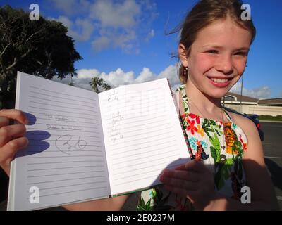 10-year-old Kyrstin Lavelle visiting from Toronto, Canada holds her notebook with a short quote, 'Dream Big Dreams' with President Obama's signature outside the McDonalds at Marine Corps Base Hawaii, USA on December 24, 2013. Kyrstin was visiting her father who is active military outside the gym where President Obama exercises and shot a few baskets earlier this morning. Photo Pool by Cory Lum/ABACAPRESS.COM Stock Photo