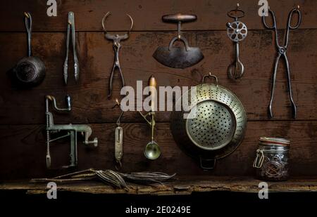 Various old utensils hanging on old wooden wall Stock Photo