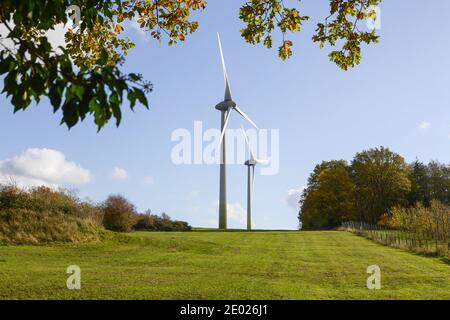 Wind Turbines in a field near a forest in Germany Stock Photo
