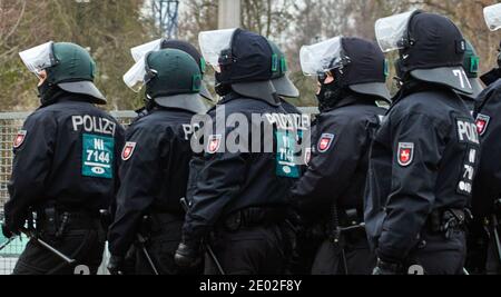 Braunschweig, Germany, December 05., 2020: Black-uniformed German police officers with helmets, visors and batons stand in a row one behind the other Stock Photo