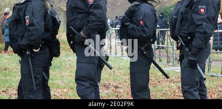 Braunschweig, Germany, December 05., 2020: Four German police officers in black uniforms with truncheons stand in a line. Stock Photo